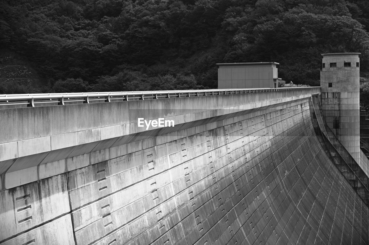 HIGH ANGLE VIEW OF DAM ON WALL BY TREES