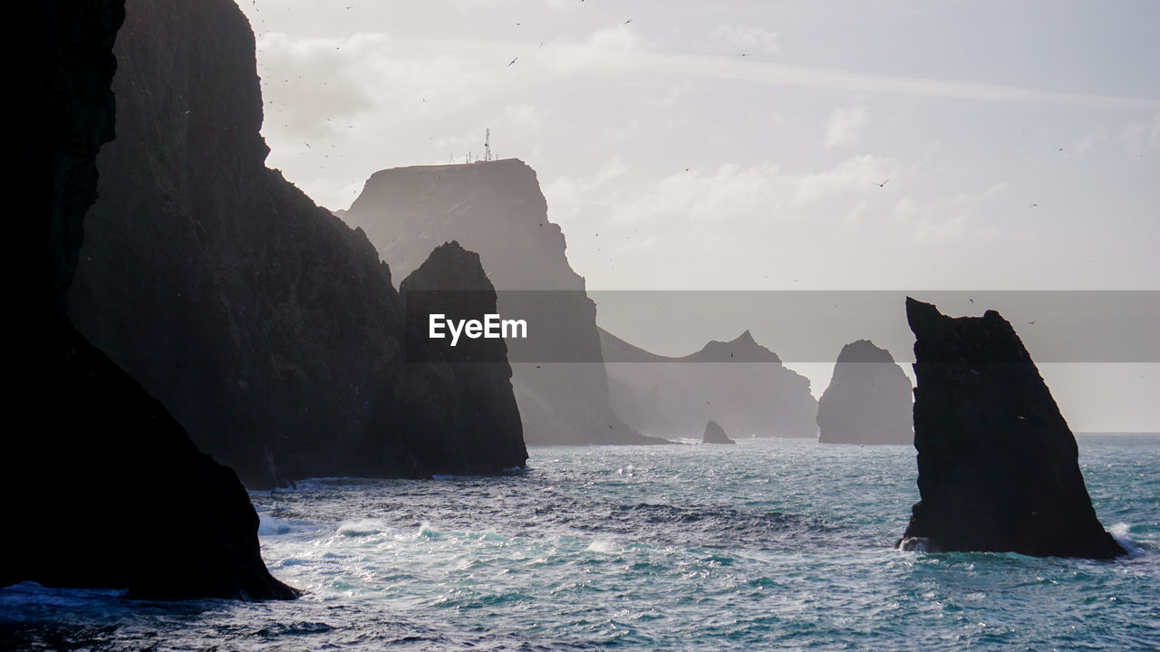 Scenic view of sea and rock formation against sky