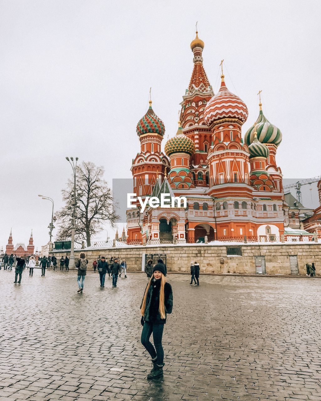 Woman standing outside st basils cathedral on street in city