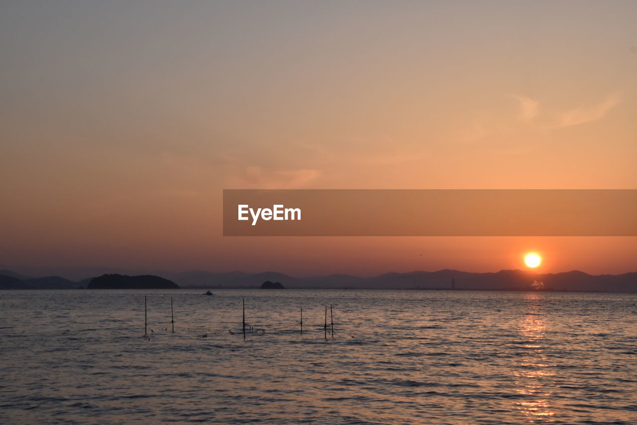 SCENIC VIEW OF SEA AGAINST SKY AT SUNSET