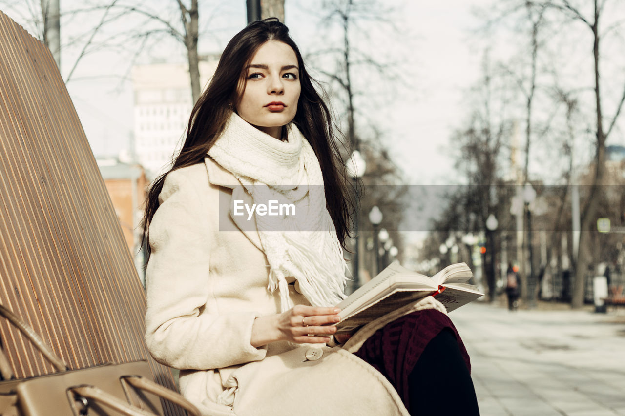 PORTRAIT OF YOUNG WOMAN LOOKING AWAY IN WINTER