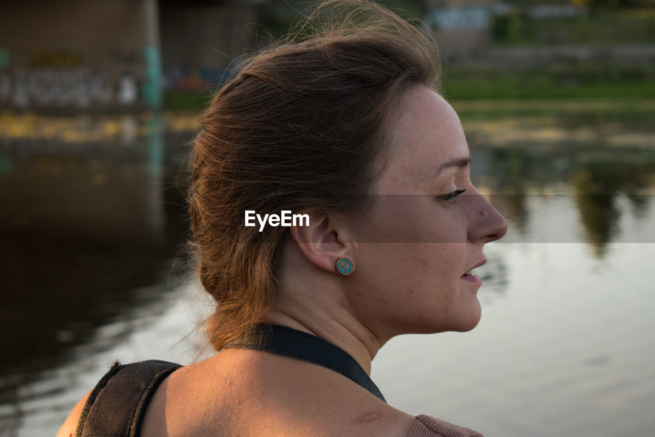 Looking into the distance, a thoughtful girl of slavic appearance with her mouth open at sunset