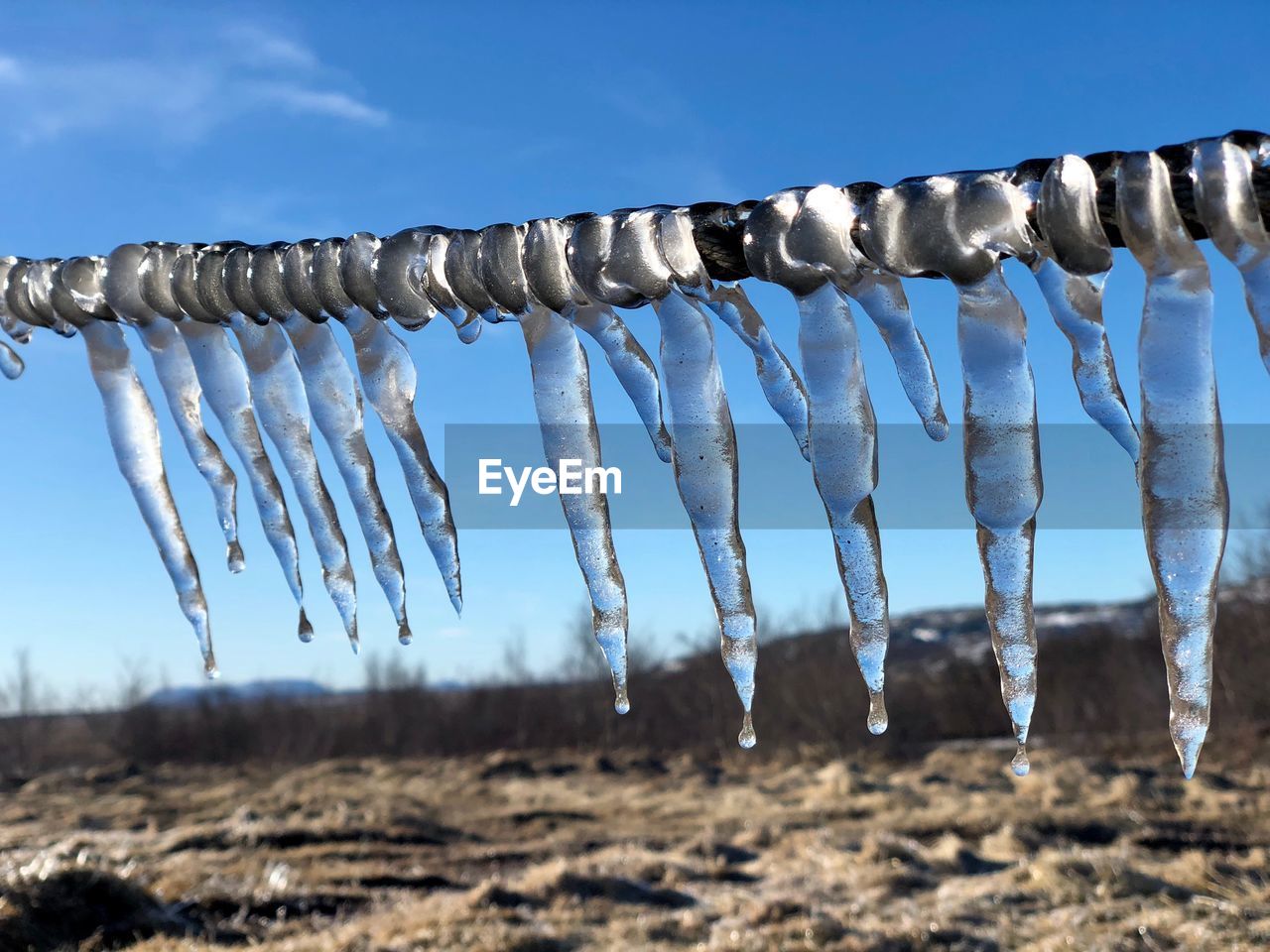 Close-up of icicles hanging against sky