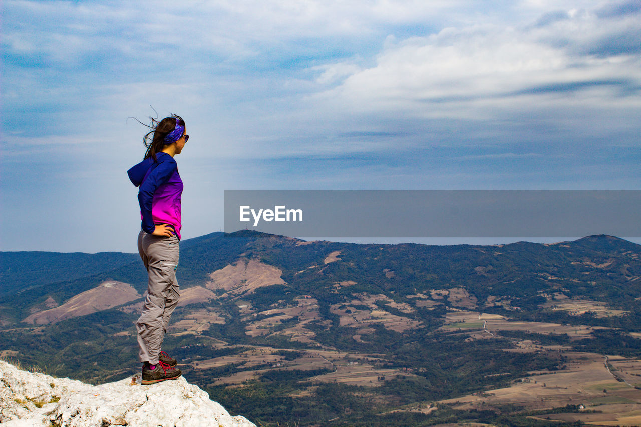 Full length of woman standing on mountain against sky