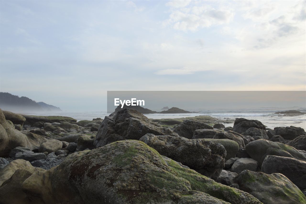 Rocks on beach against sky