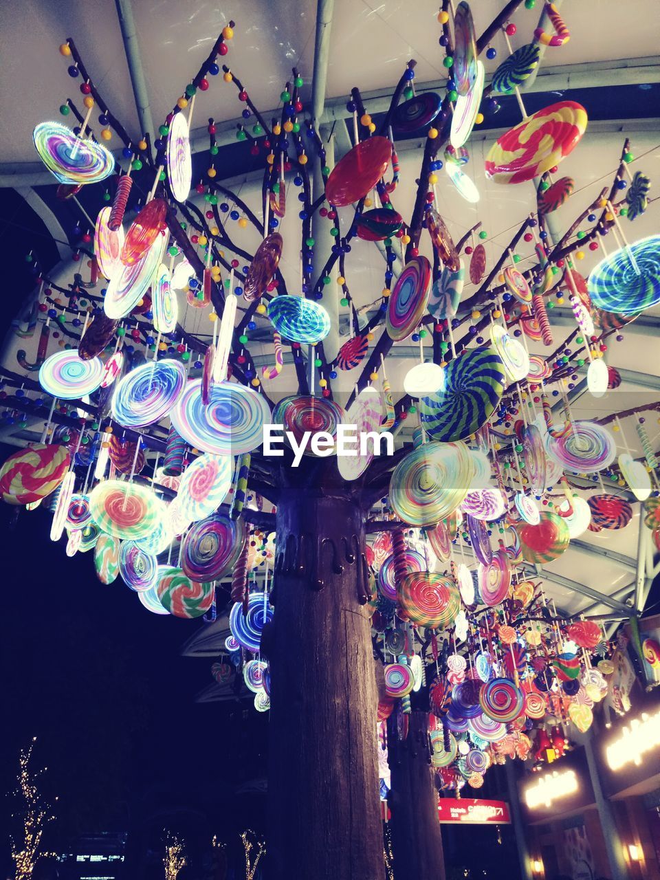 LOW ANGLE VIEW OF ILLUMINATED LANTERNS HANGING AT MARKET