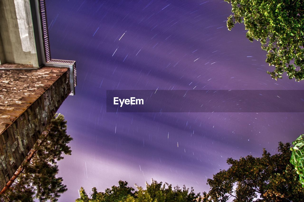 Low angle view of star trails in sky at night