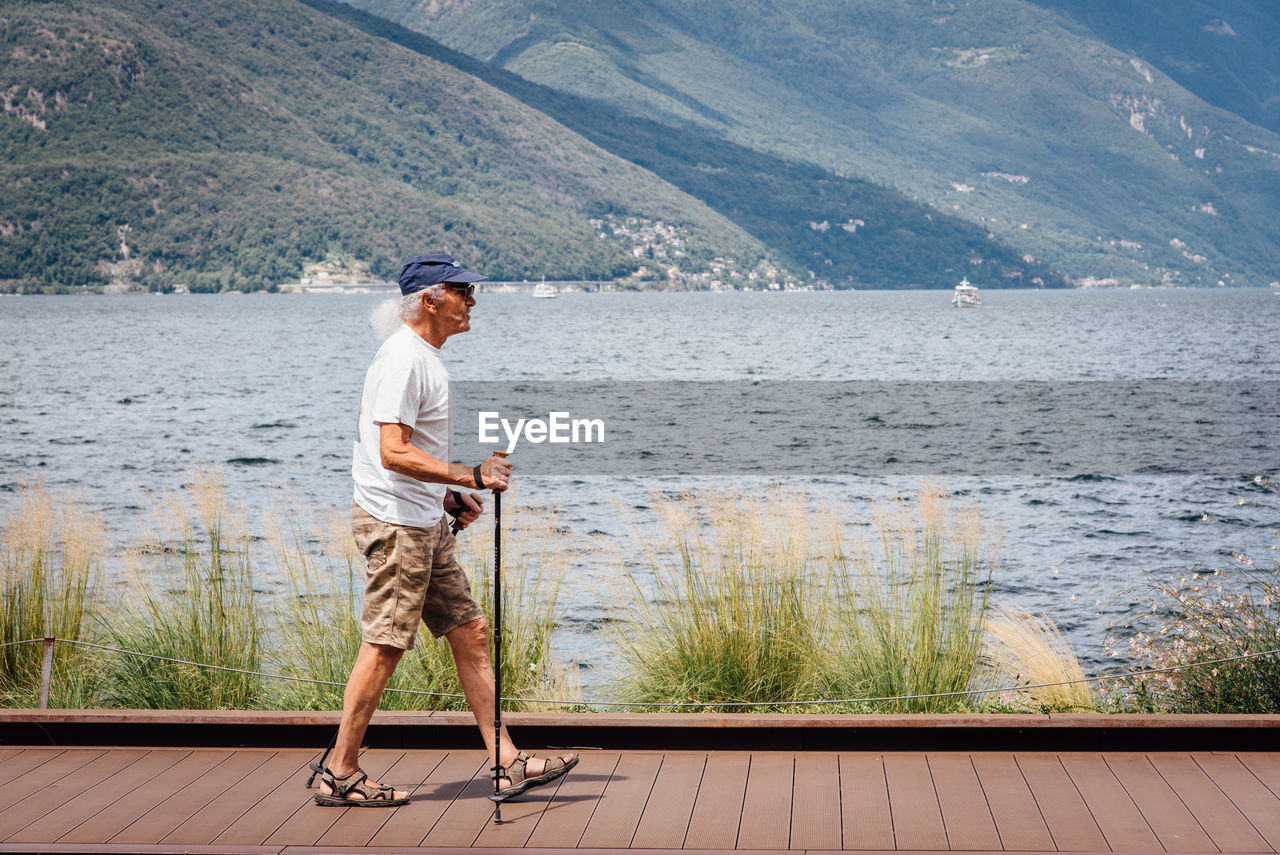 MAN LOOKING AT LAKE