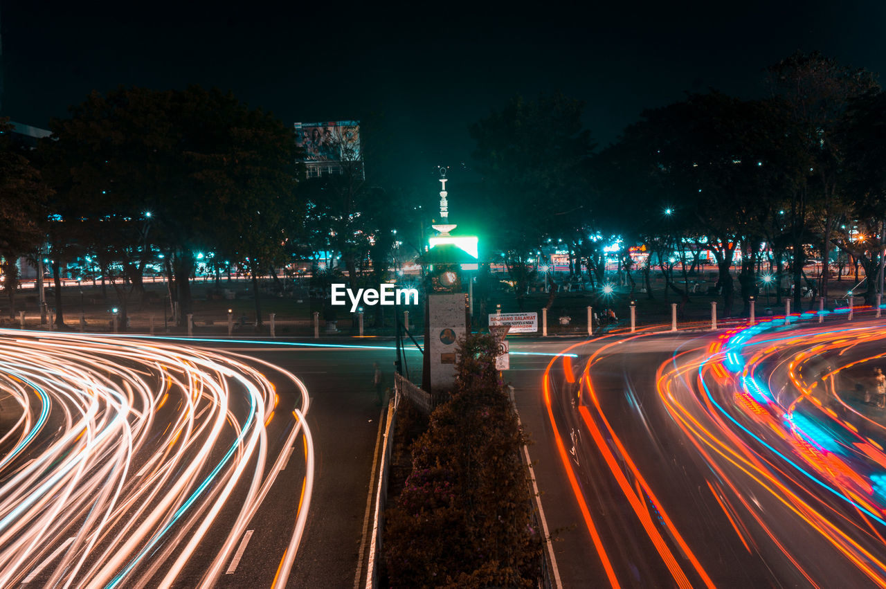 LIGHT TRAILS ON ROAD AGAINST SKY AT NIGHT