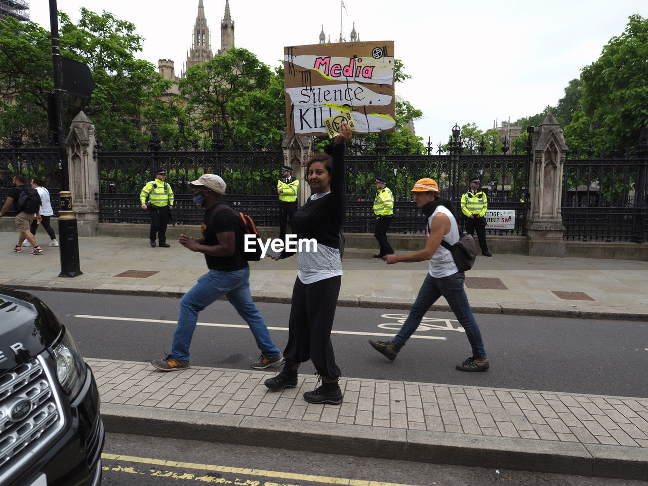 PEOPLE WALKING ON ROAD AGAINST CITY