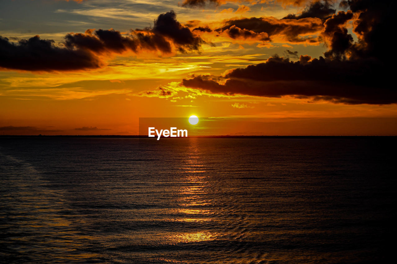 Scenic view of sea against orange sky