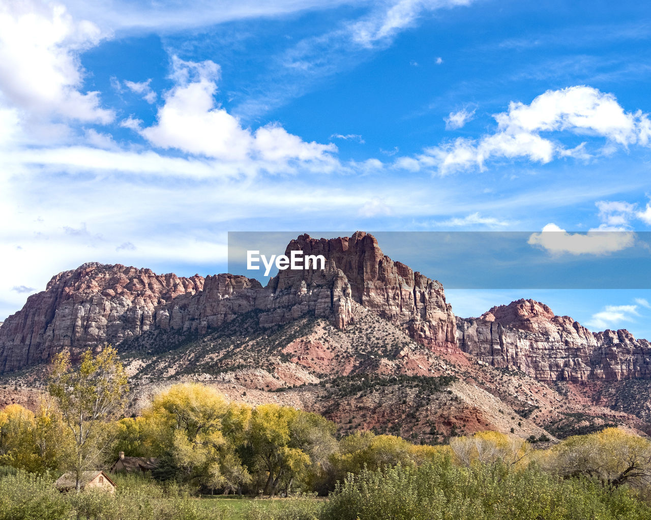 Rock formations on landscape against cloudy sky