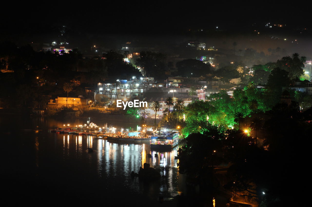 ILLUMINATED CITY BY RIVER AT NIGHT