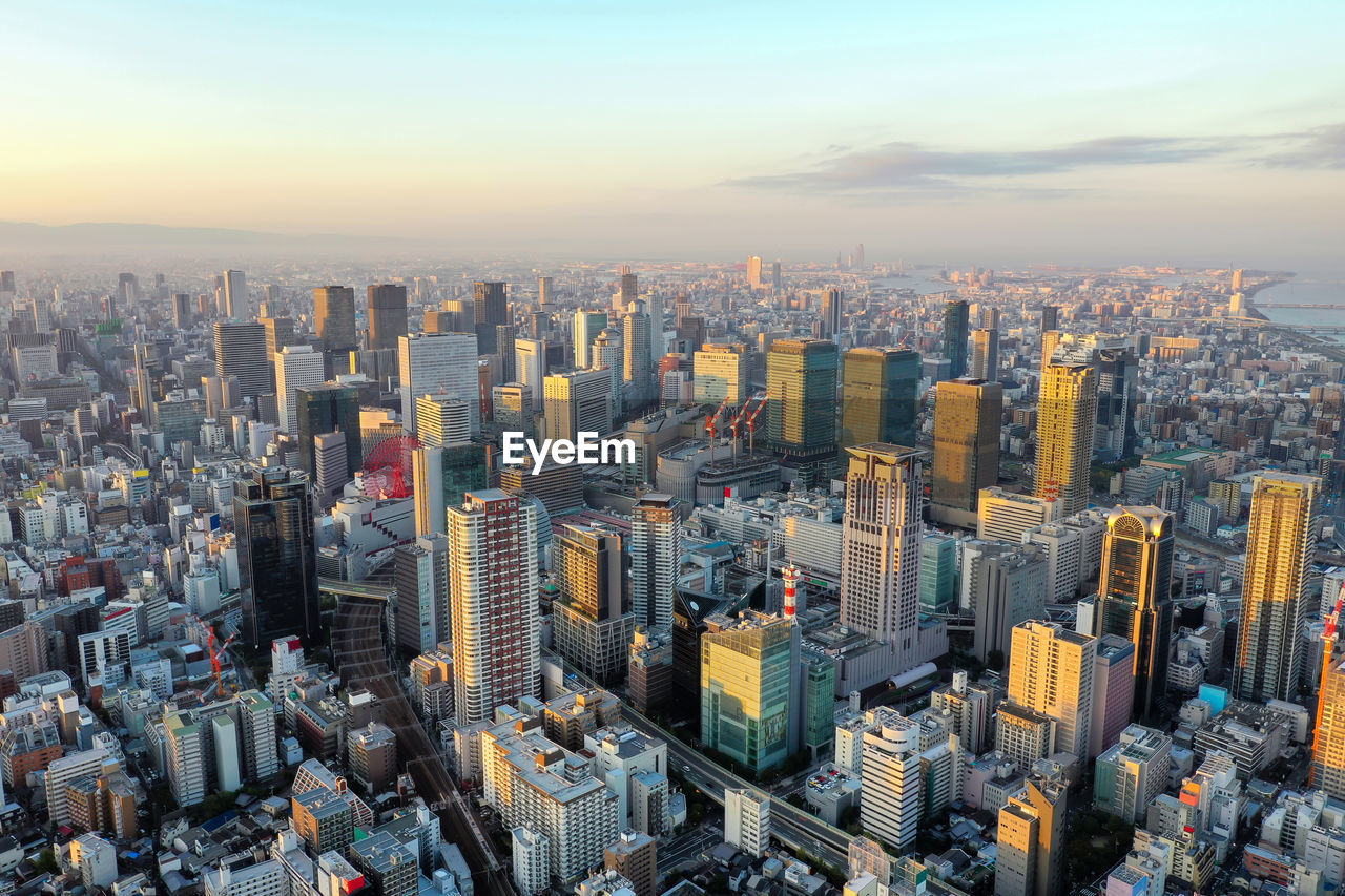 HIGH ANGLE VIEW OF MODERN BUILDINGS AGAINST SKY IN CITY