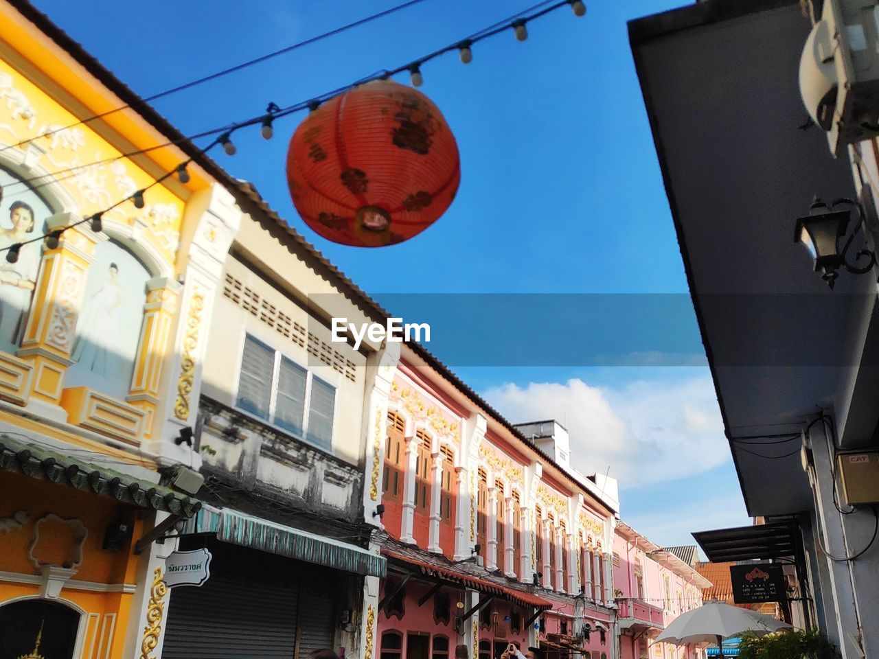 LOW ANGLE VIEW OF LANTERNS HANGING AMIDST BUILDINGS IN CITY