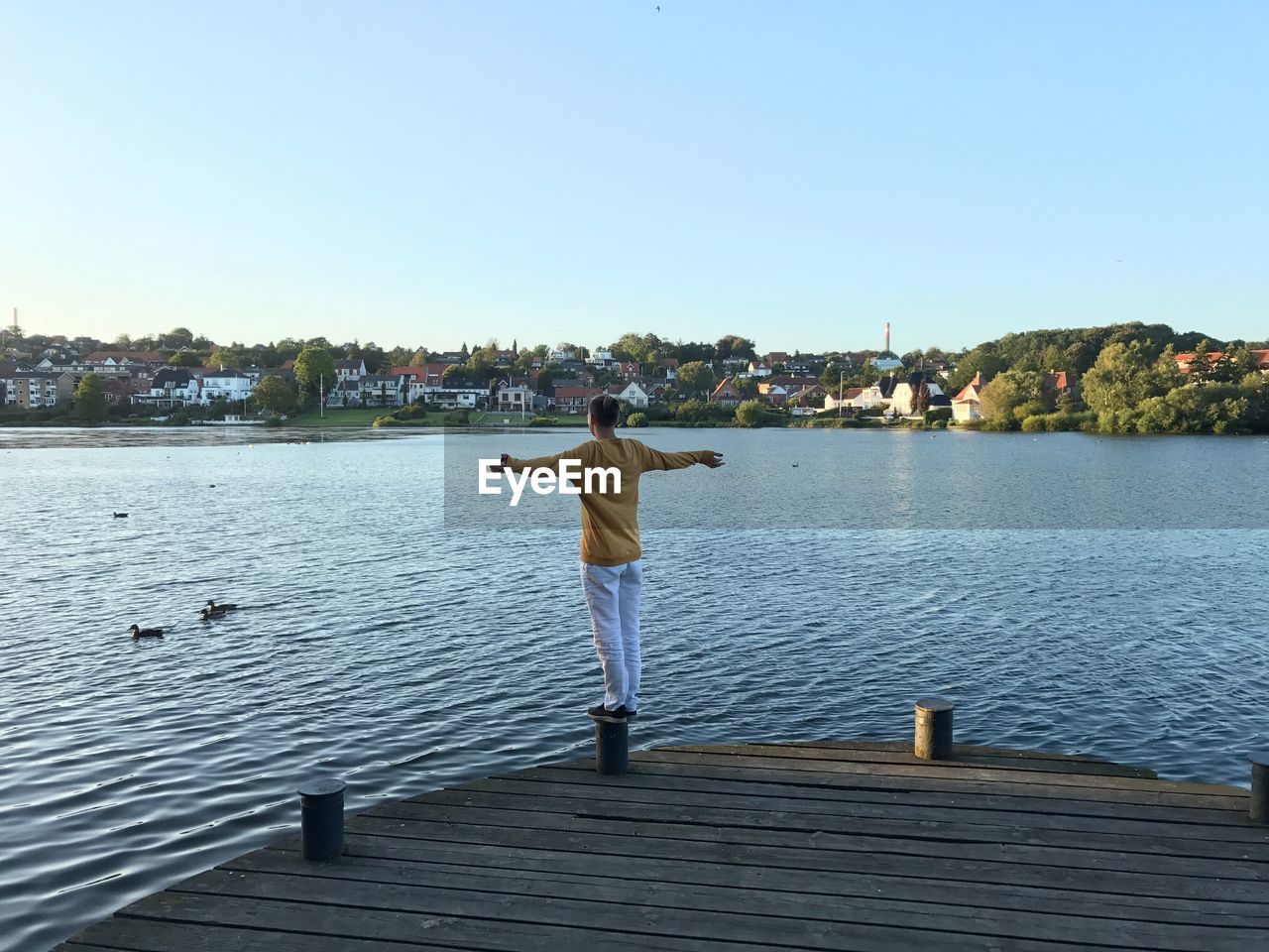 FULL LENGTH REAR VIEW OF MAN STANDING ON JETTY