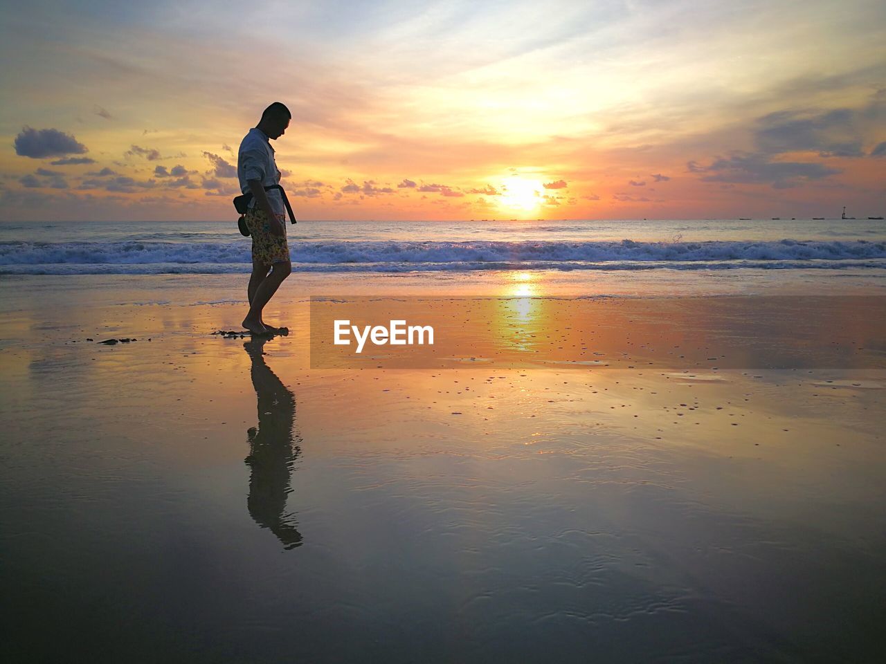 FULL LENGTH OF PERSON ON BEACH AGAINST SKY DURING SUNSET