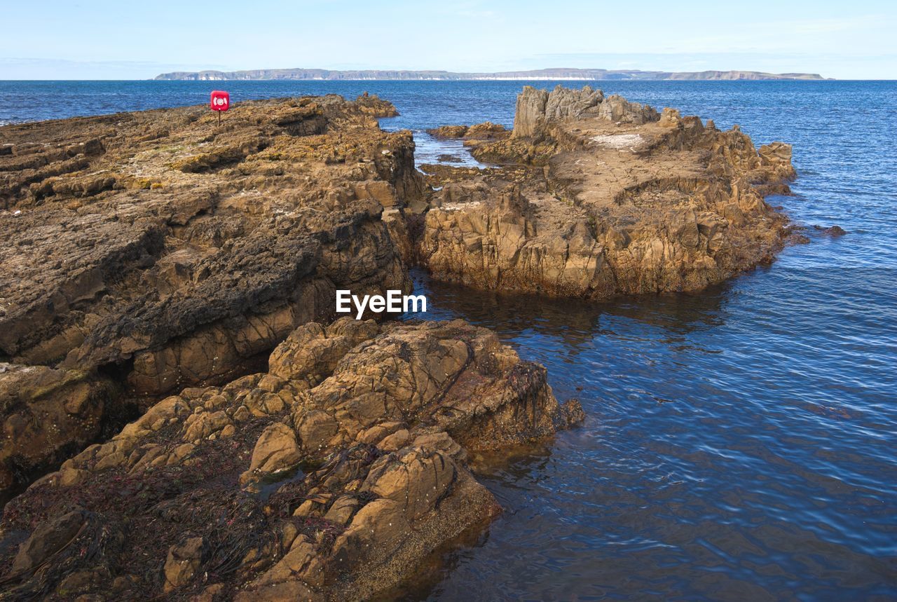 ROCKS ON SHORE AGAINST SKY