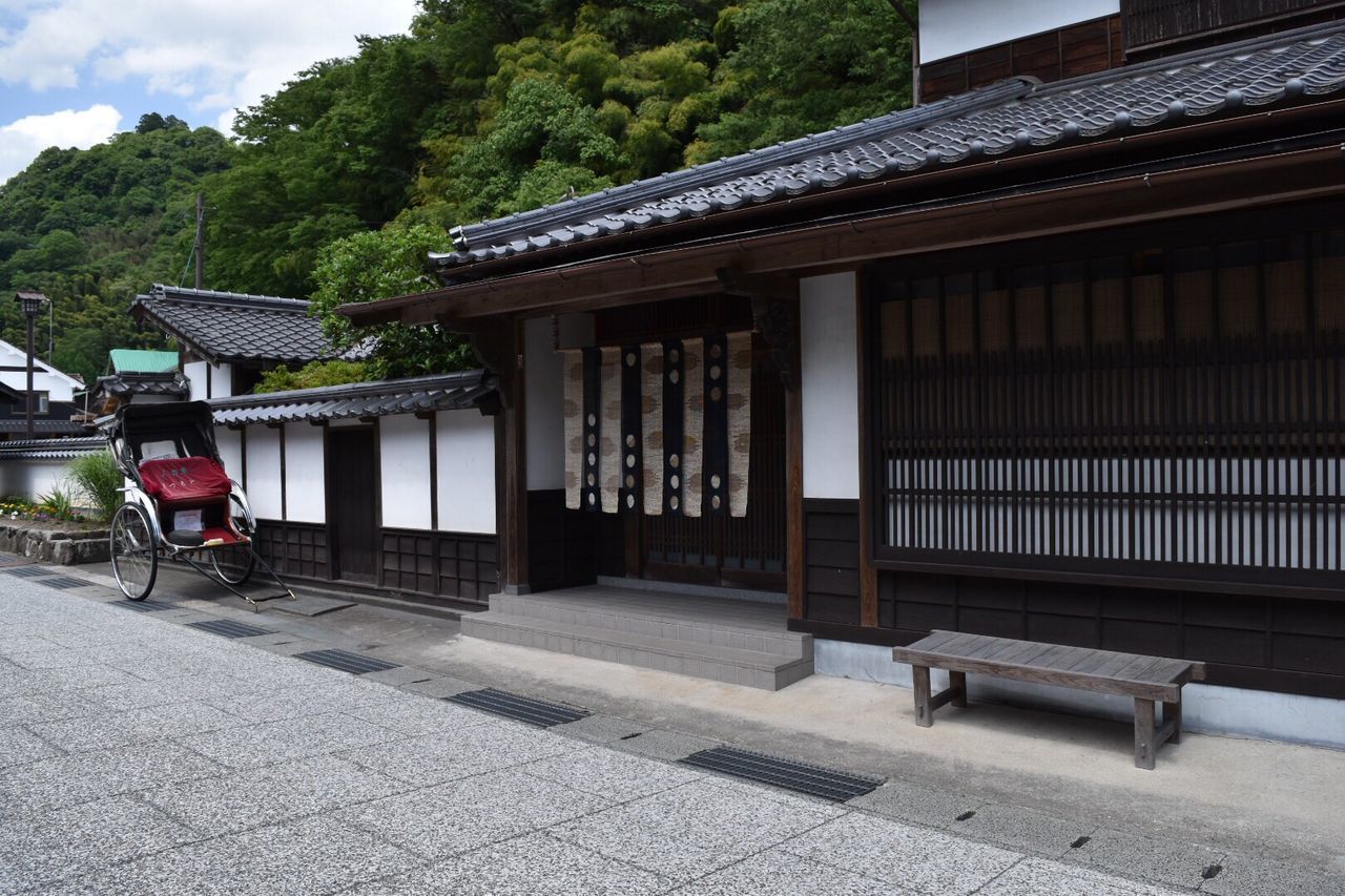 MAN IN FRONT OF HOUSE