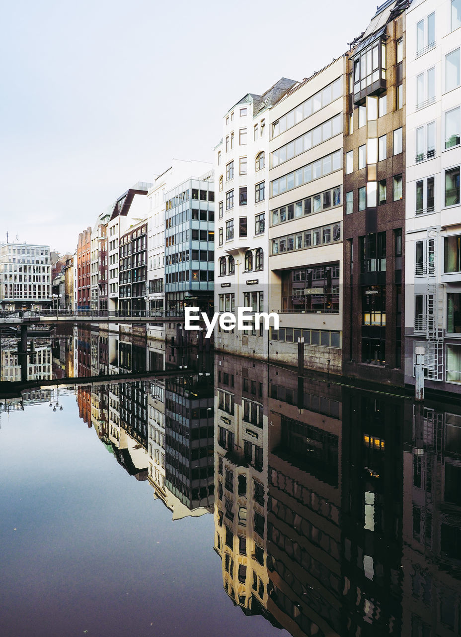 Reflection of buildings on river against sky