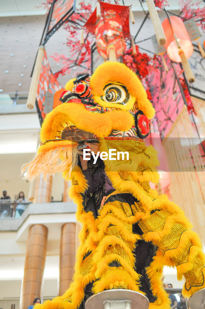representation, yellow, chinese new year, carnival, animal representation, low angle view, celebration, architecture, creativity, tradition, built structure, no people, decoration, craft, holiday, festival, human representation, hanging, event