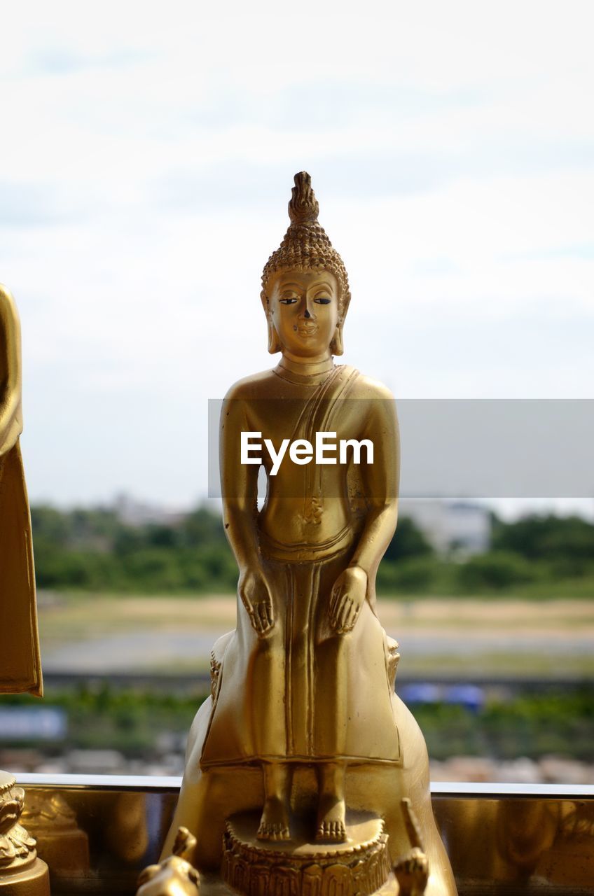 SCULPTURE OF BUDDHA AGAINST SKY