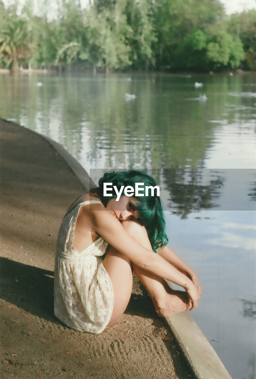 WOMAN SITTING ON A LAKE