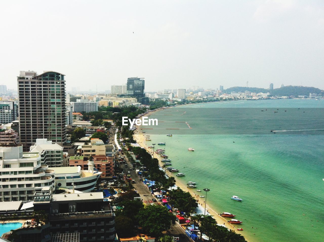 Cityscape by sea against clear sky