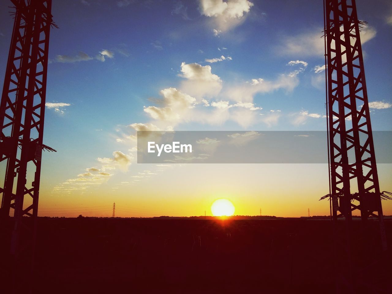 Silhouette towers against sky during sunrise