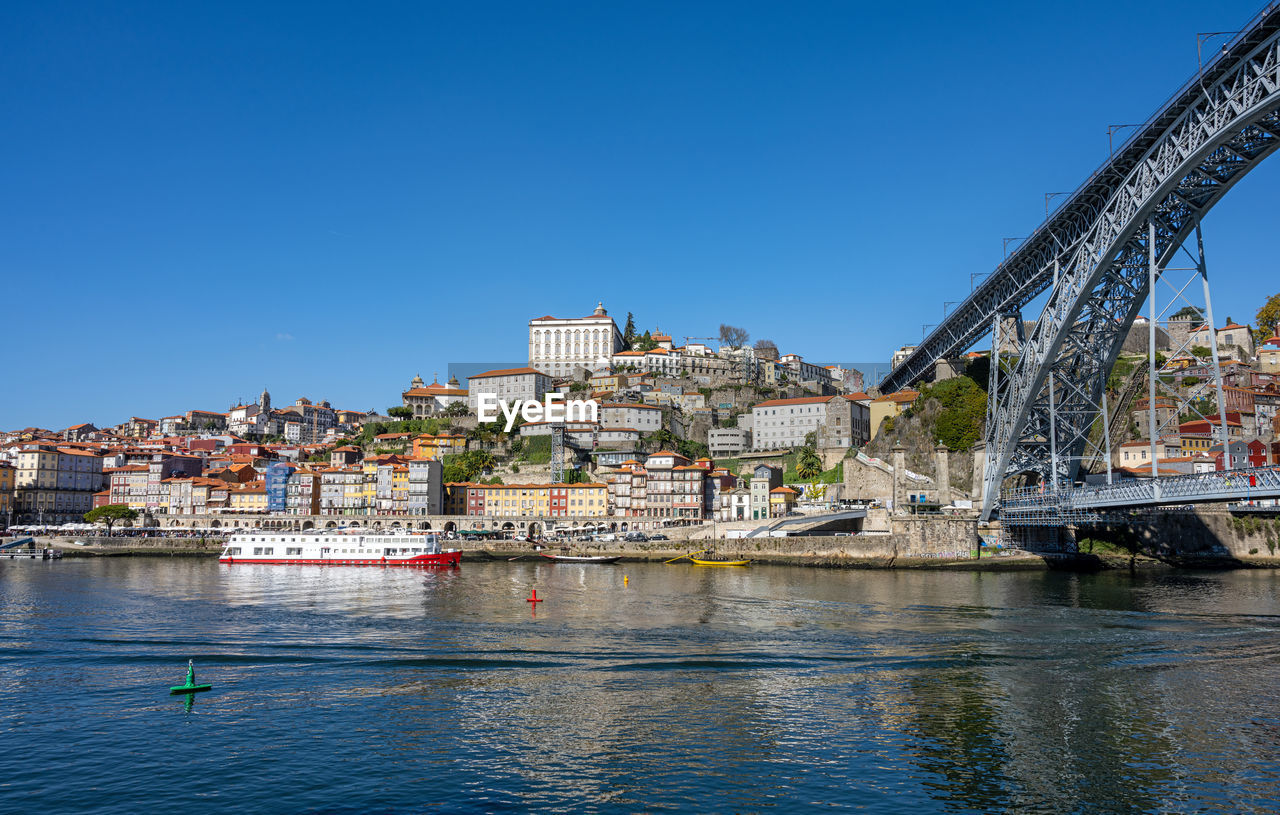 The old town of porto with the river douro and the famous iron bridge on a sunny day
