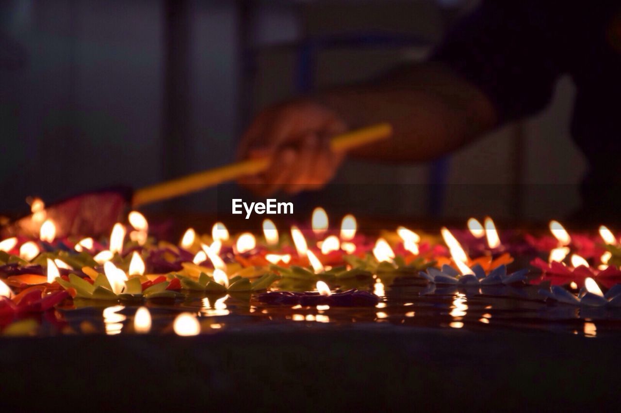 CLOSE-UP OF ILLUMINATED CANDLES ON DISPLAY