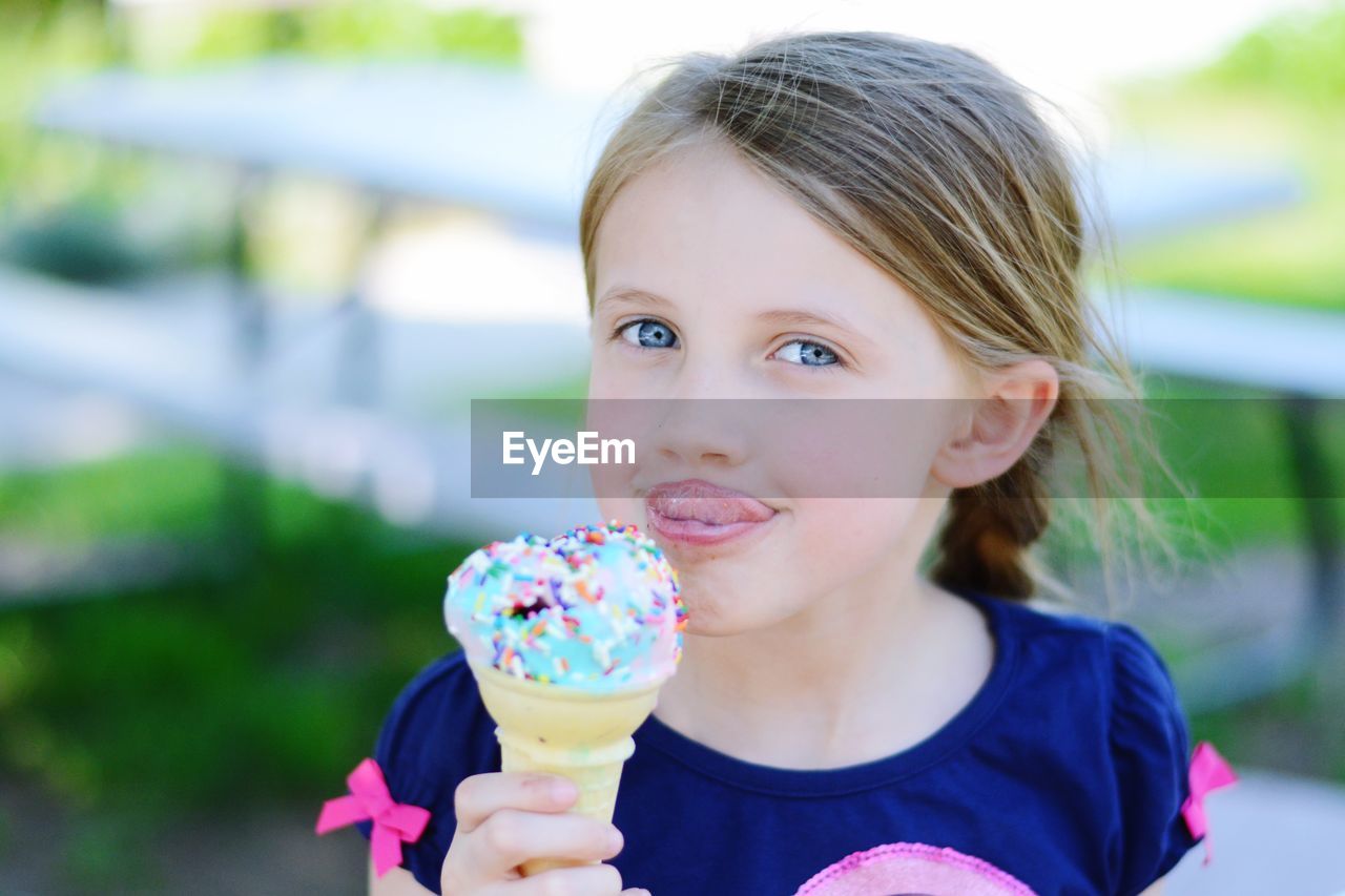 Portrait of cute girl sticking out tongue while holding ice cream