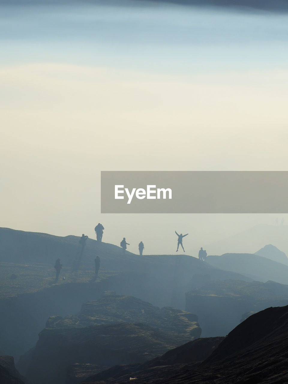 Low angle view of silhouette people on mountain against sky