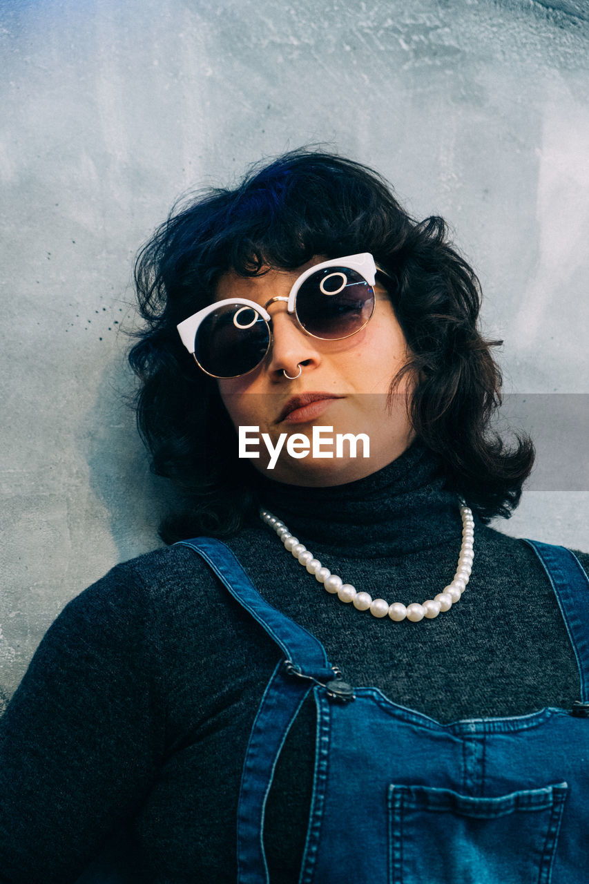 Woman with vintage cool attitude against wall