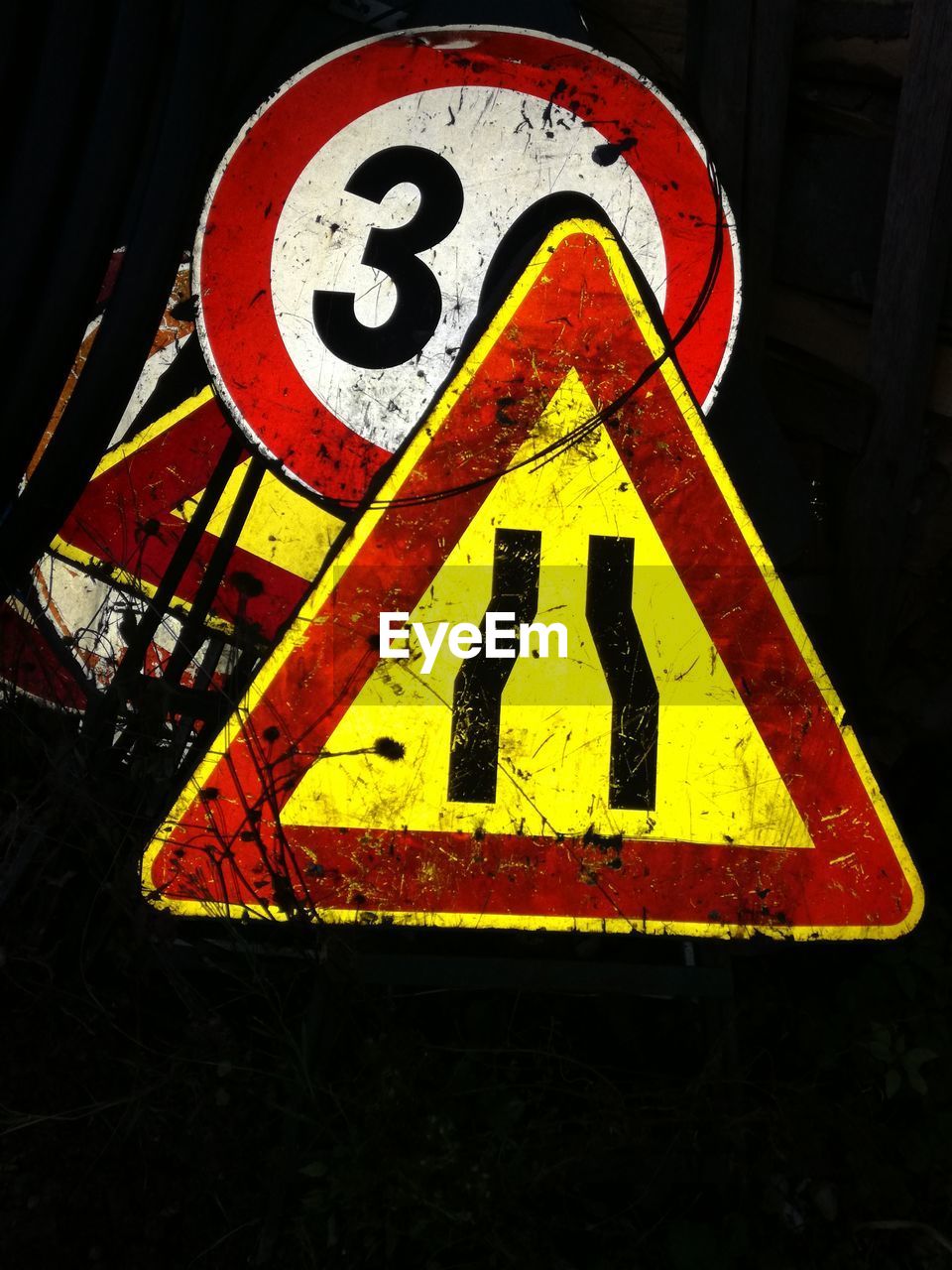 Close-up of road signs against black background