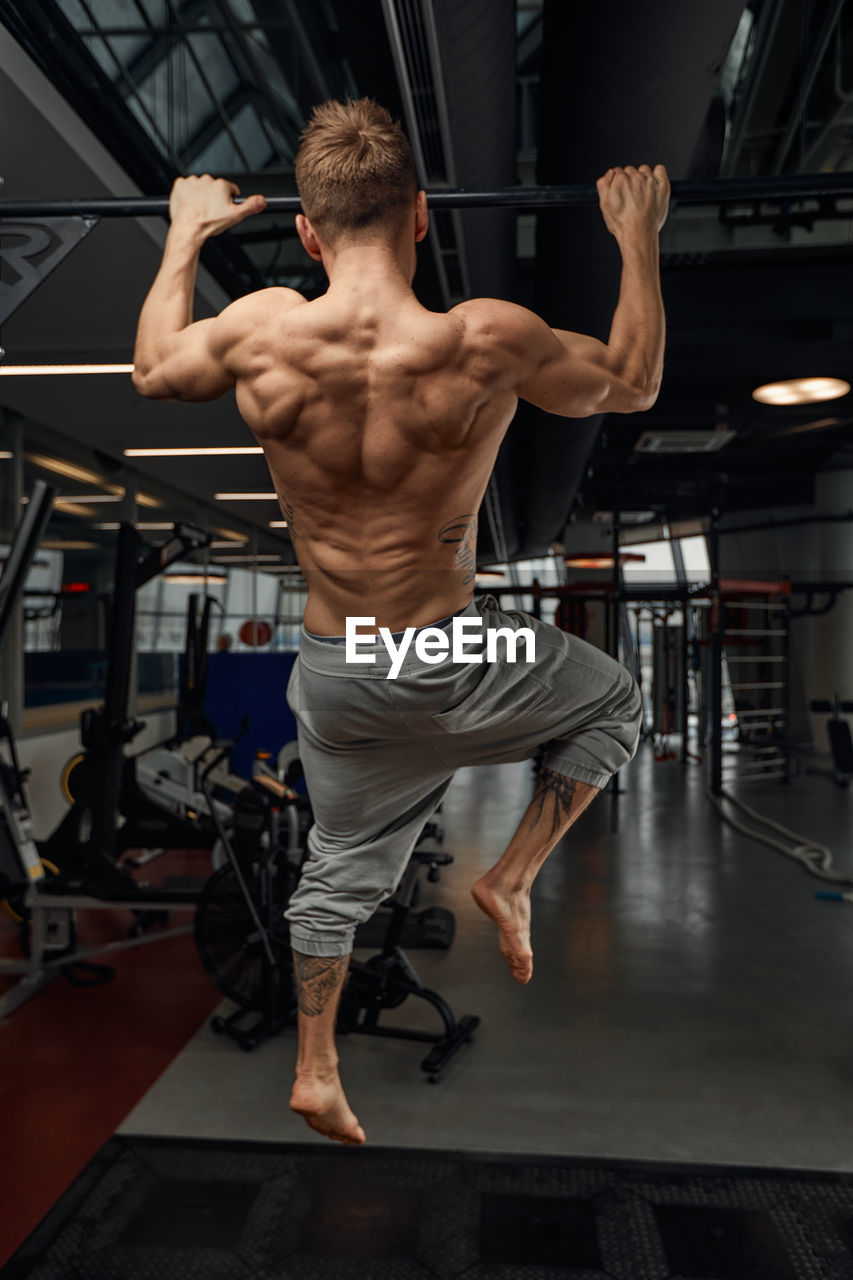 side view of man exercising in gym