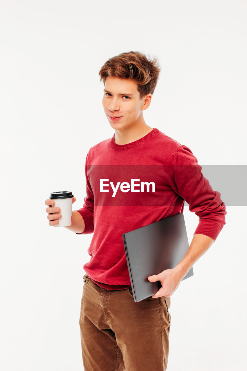 LOW ANGLE VIEW OF YOUNG MAN DRINKING COFFEE