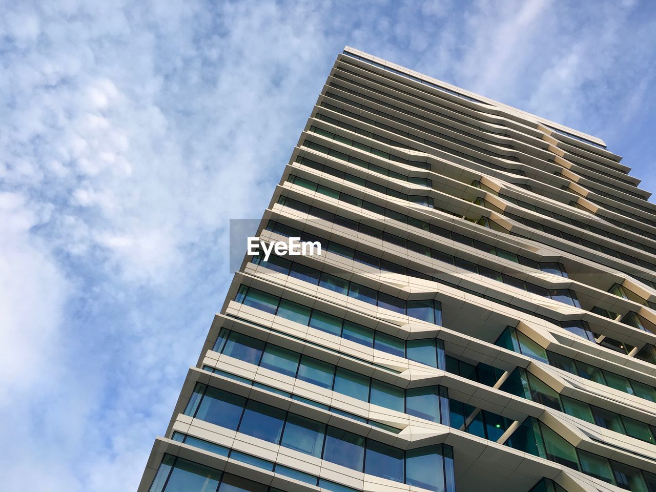 LOW ANGLE VIEW OF MODERN BUILDING AGAINST CLOUDY SKY