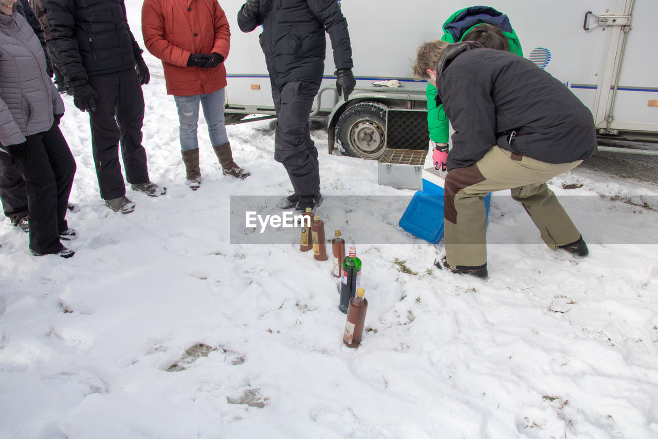 PEOPLE STANDING ON SNOWY FIELD