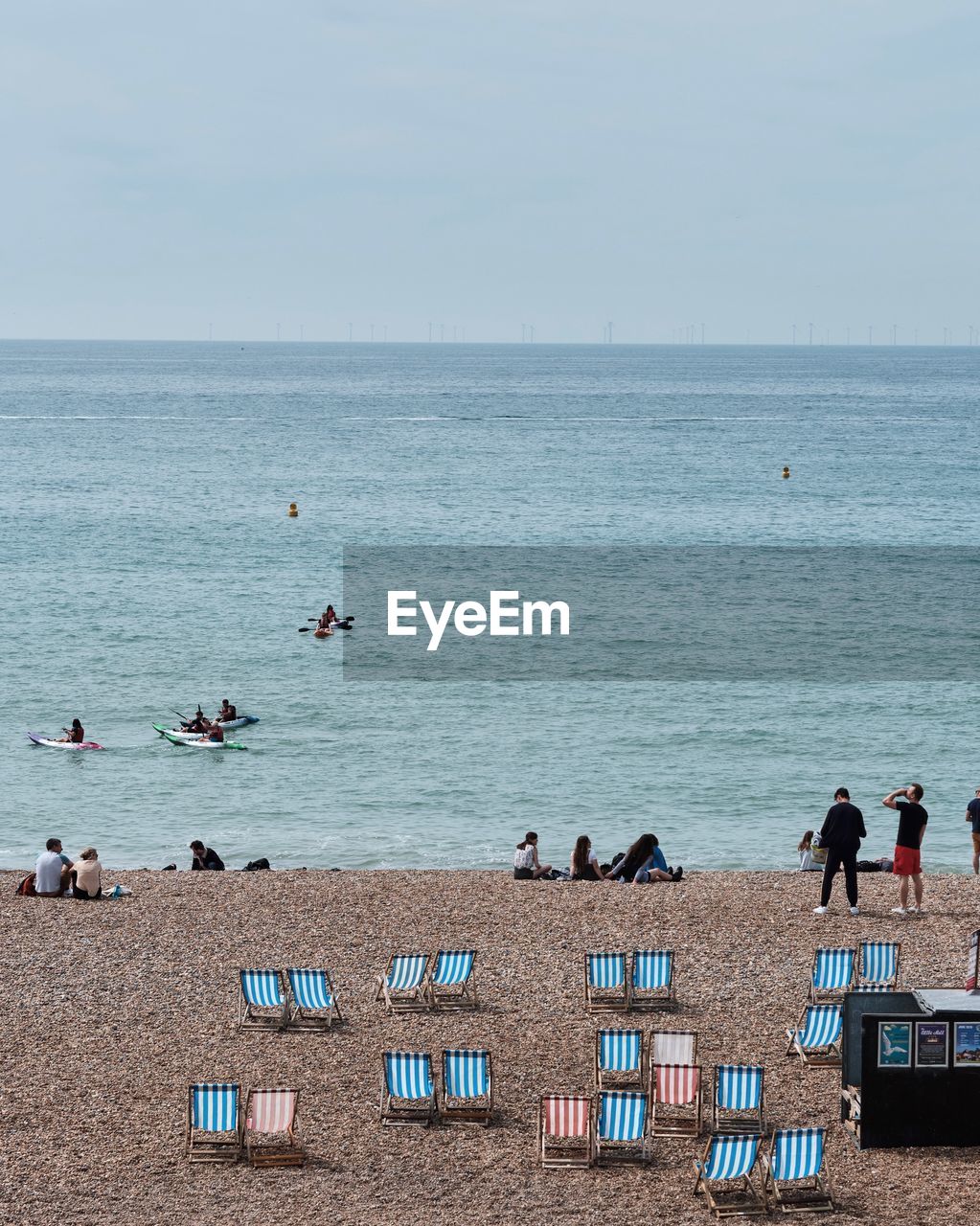 People at beach against sky