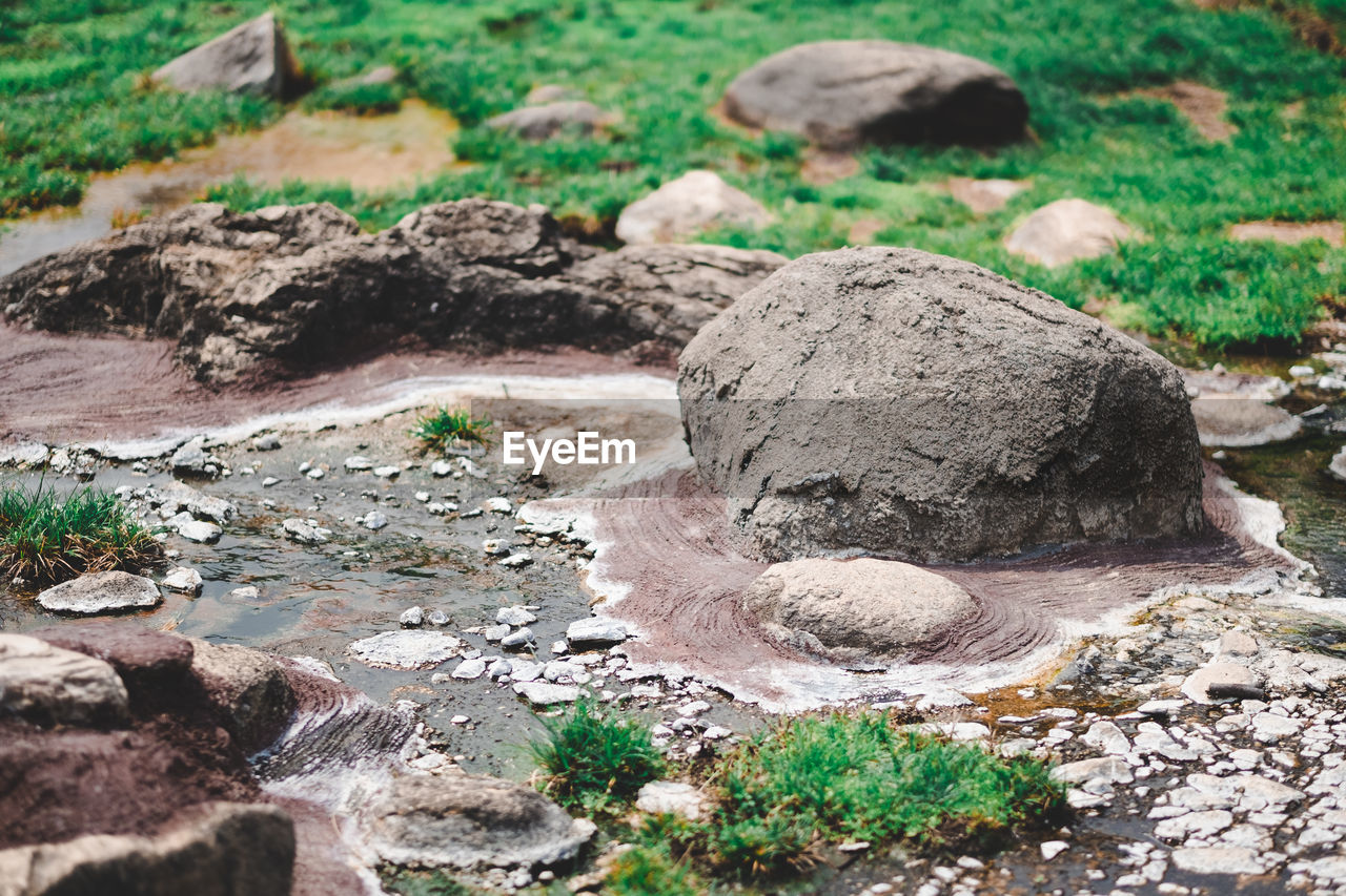 CLOSE-UP OF ROCKS ON FIELD