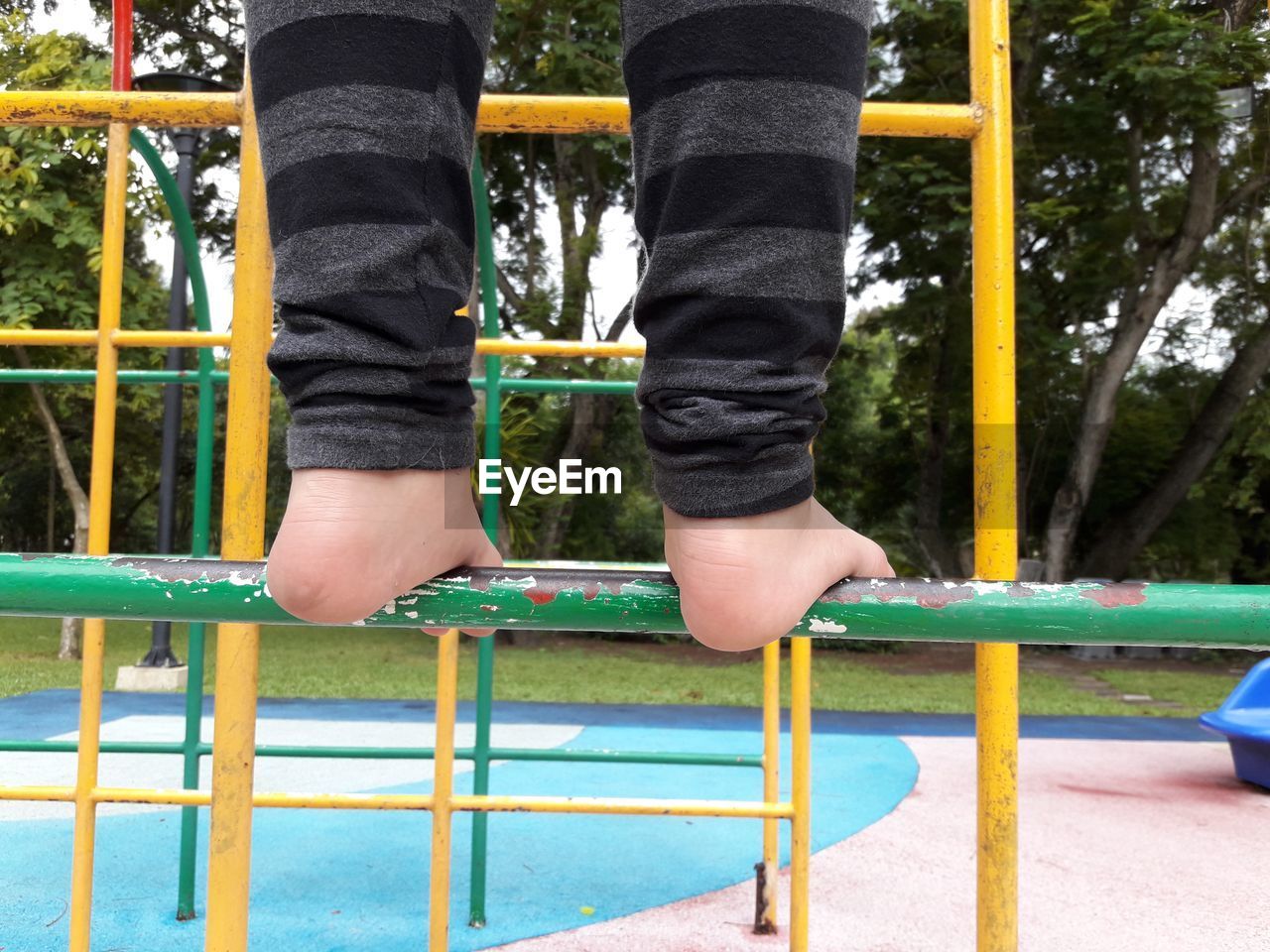 LOW SECTION OF CHILD PLAYING ON PLAYGROUND