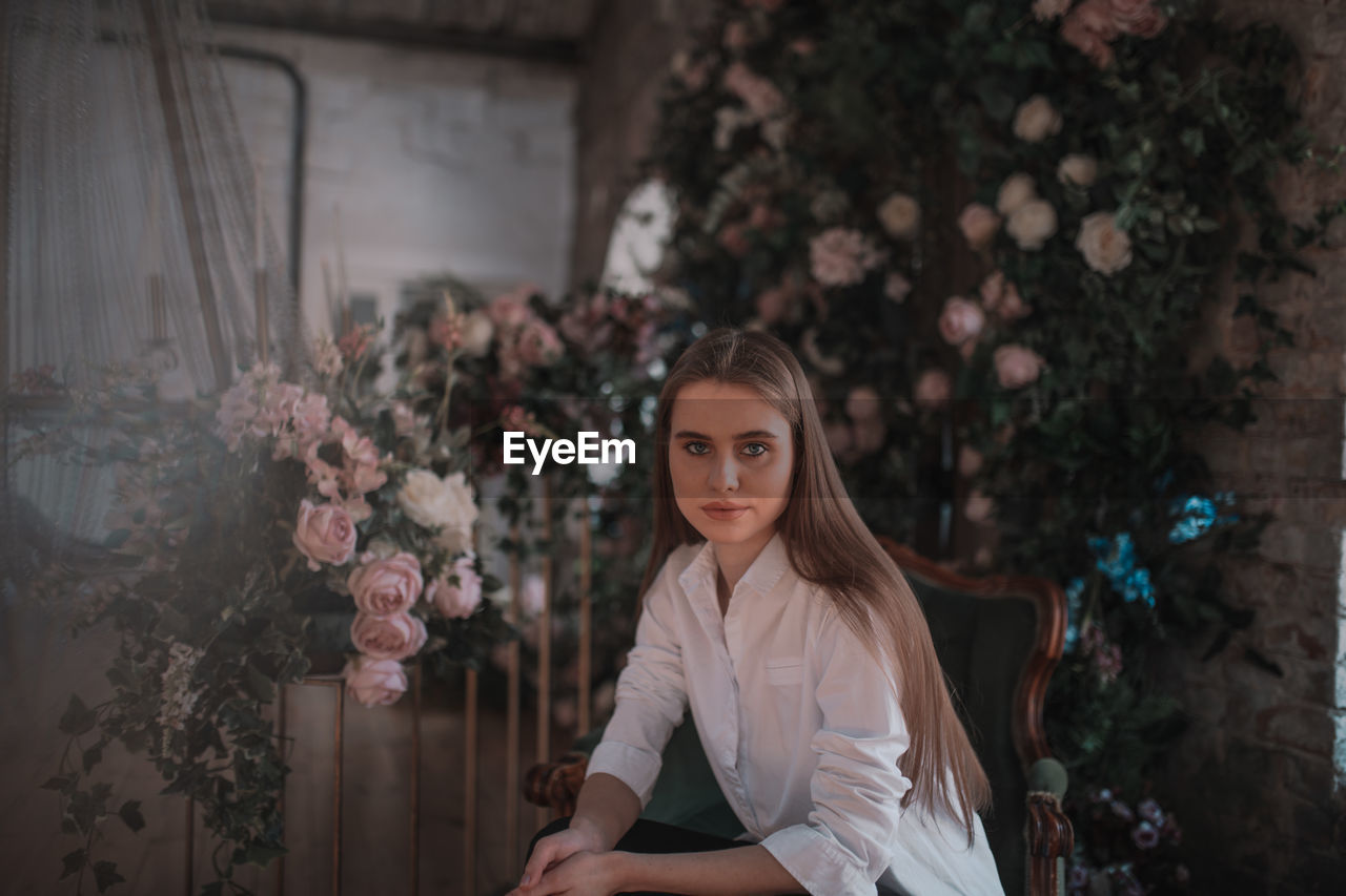 Portrait of young woman against plants