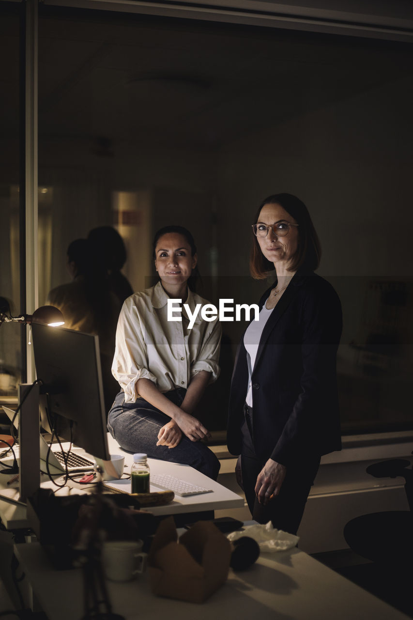 Portrait of multiracial female colleagues in office at night