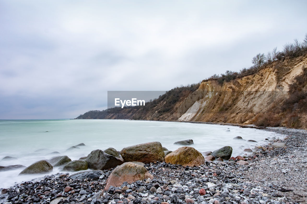 Boulders at flintstone pebbles beach on german ruegen island. typical white chalk cliff of shore