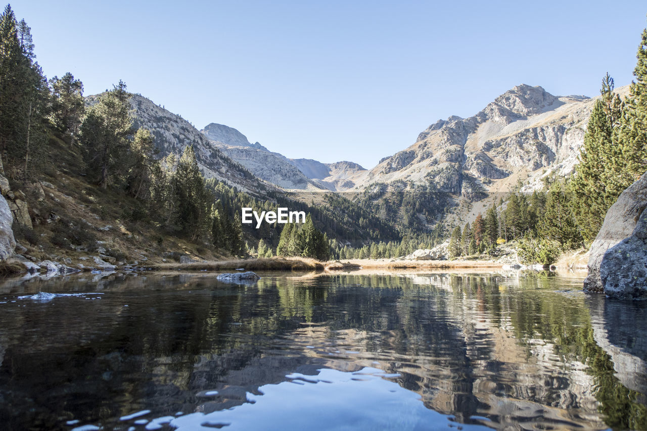 Scenic view of lake and mountains against clear sky