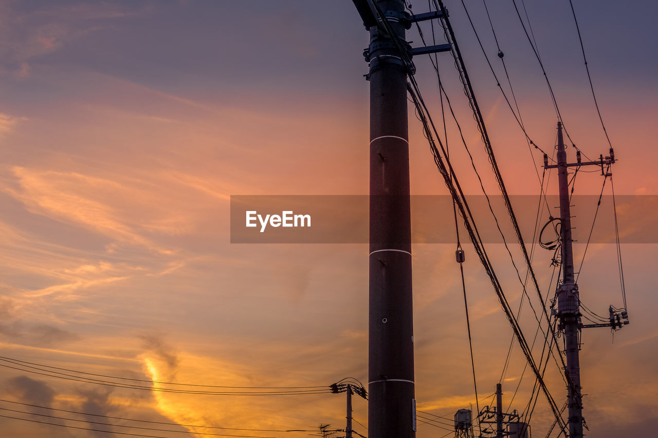 low angle view of electricity pylon against cloudy sky during sunset