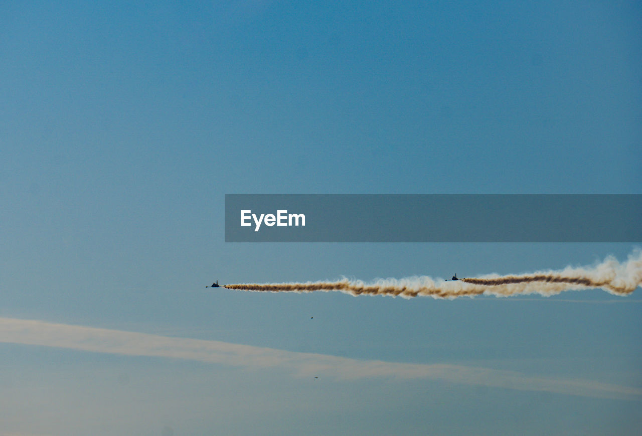 Low angle view of airplane flying against blue sky