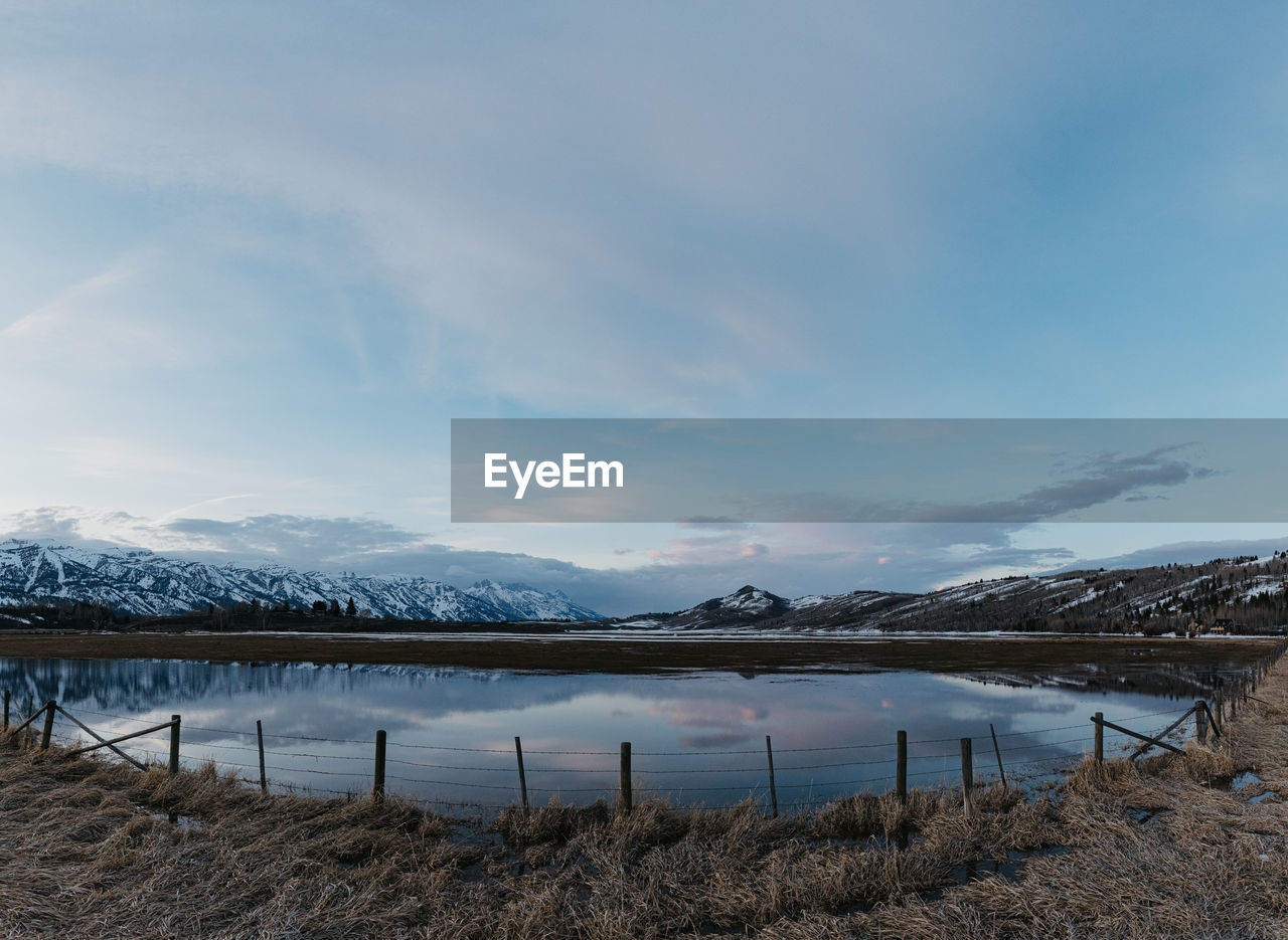 Flooded ranch and fence during spring snow melt in jackson, wyoming