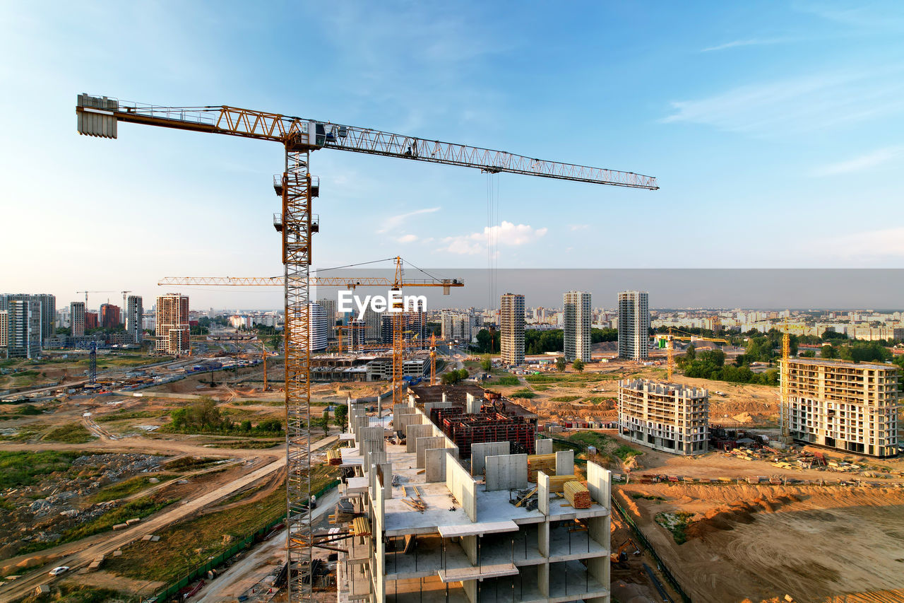 CRANE AT CONSTRUCTION SITE AGAINST SKY